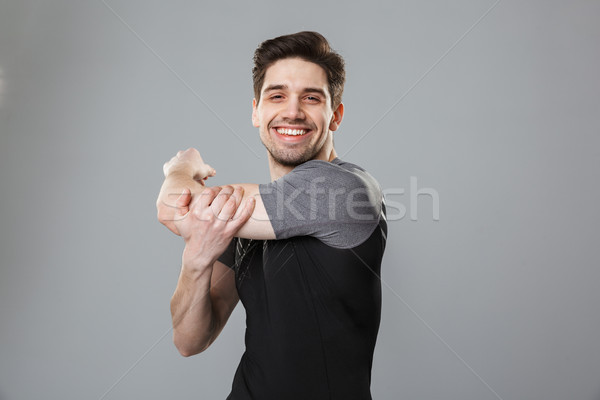 Portrait of a smiling young sportsman warming up Stock photo © deandrobot
