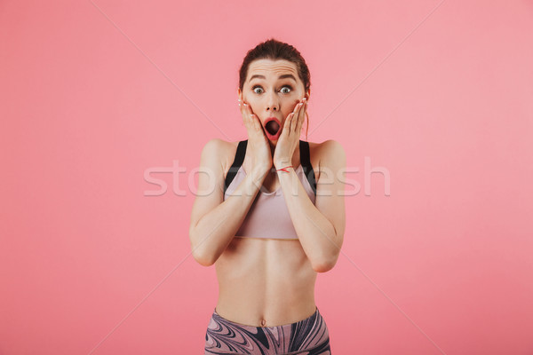 Shocked sportswoman holding her cheeks and looking at the camera Stock photo © deandrobot