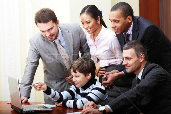 Kid boy explains multi ethnic business team how to work Stock photo © deandrobot