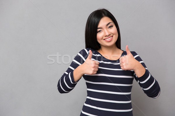 Smiling asian girl giving thumbs-up Stock photo © deandrobot