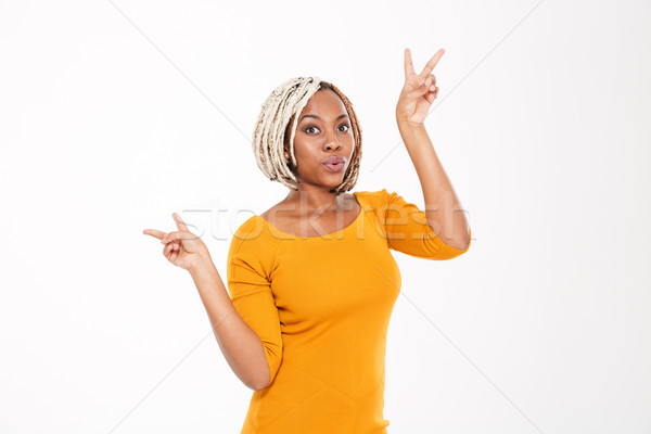 Playful excited african american young woman showing peace sign  Stock photo © deandrobot