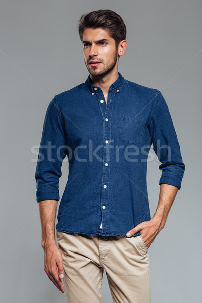 Portrait of a casual man standing with hand in pocket Stock photo © deandrobot