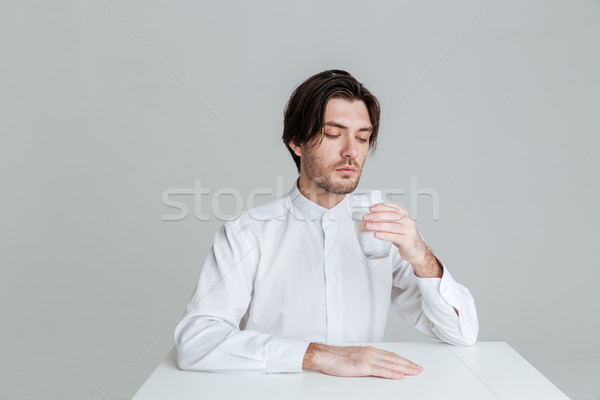Man drinking from water glass while sitting at the table Stock photo © deandrobot