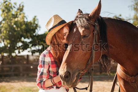 Woman cowgirl taking care of her horse on ranch Stock photo © deandrobot