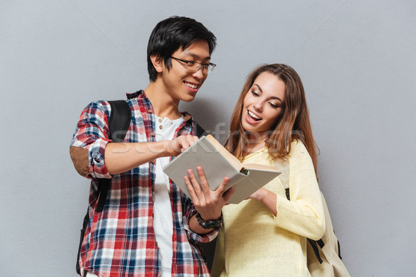 Retrato sorridente multicultural casal leitura livro Foto stock © deandrobot