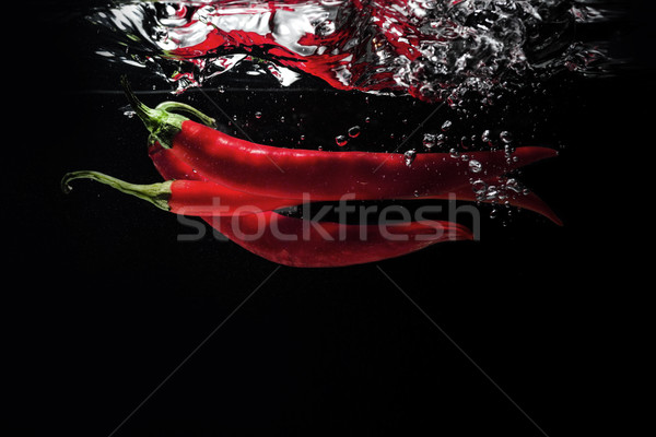 Rot Chilischoten fallen Wasser isoliert schwarz Stock foto © deandrobot