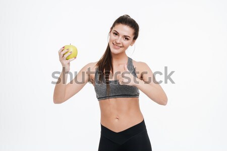 Fitness woman holding apple and showing thumbs up Stock photo © deandrobot