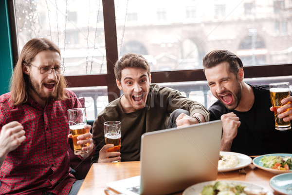 Feliz hombres amigos sesión Servicio comer Foto stock © deandrobot