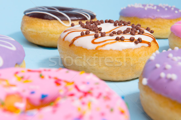 Colorful sweeties donuts over blue table background. Stock photo © deandrobot