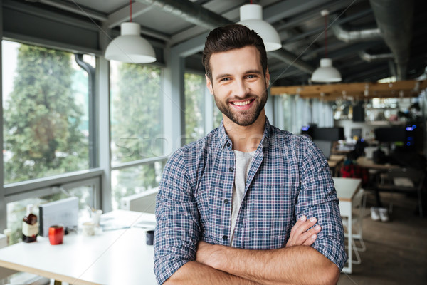 Cheerful man standing in office coworking Stock photo © deandrobot