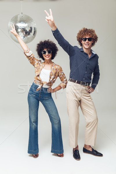 Emotional smiling retro loving couple dancing near disco ball. Stock photo © deandrobot