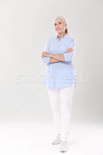 Full-length portrait of charming old lady in blue shirt and whit Stock photo © deandrobot