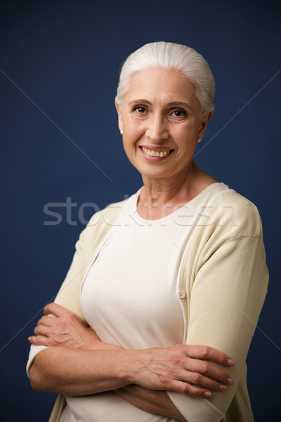 Photo of cheerful mature woman in beige tshirt, standing with cr Stock photo © deandrobot