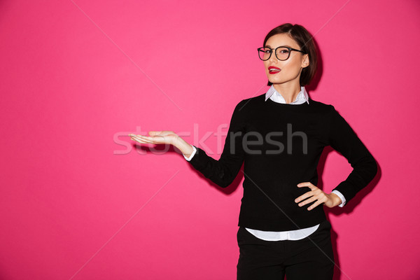 Pretty smiling woman pointing at copy space isolated Stock photo © deandrobot