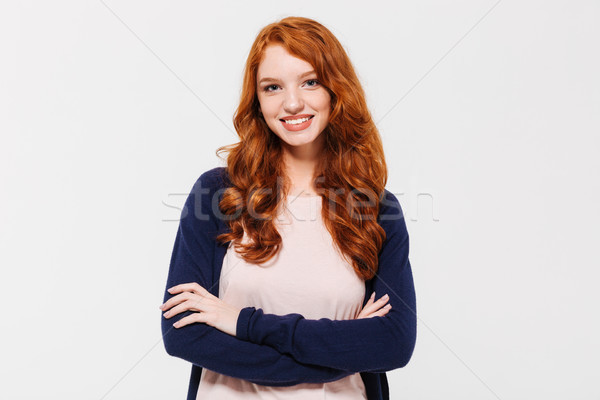 Cheerful pretty young redhead lady with arms crossed Stock photo © deandrobot