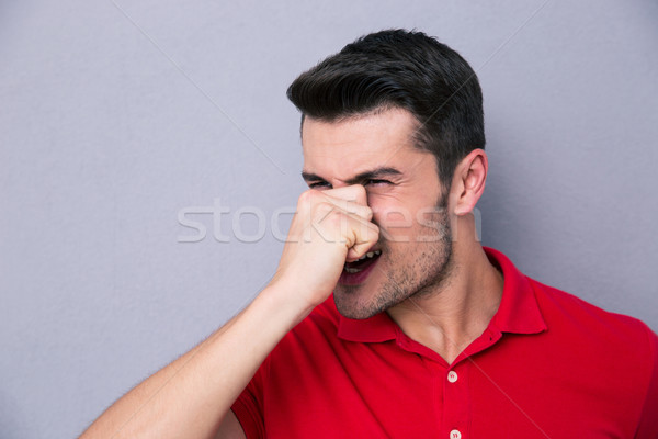Casual man covering his nose Stock photo © deandrobot
