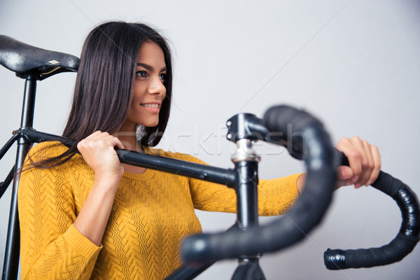 Woman holding bicycle on shoulder Stock photo © deandrobot