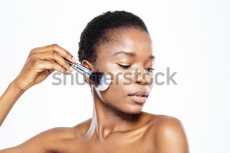 Afro american woman applying makeup with brush Stock photo © deandrobot