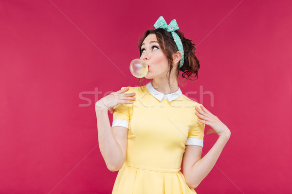 Thoughtful attractive young woman blowing bubble from chewing gum Stock photo © deandrobot