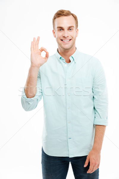 Happy man showing ok sign with fingers over white background Stock photo © deandrobot