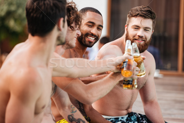 Handsome young smiling men having fun in swimming pool Stock photo © deandrobot