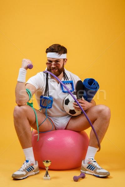 Portrait of a sports man sitting on a fitness ball Stock photo © deandrobot