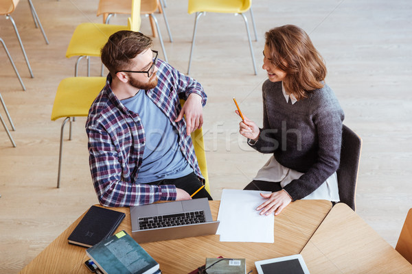 Stock photo: Cheerful Students In Library Writing Notes