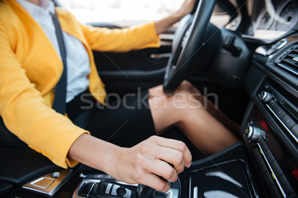 Woman shifting gears on gearbox and driving car Stock photo © deandrobot