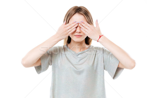 Young cute girl covering eyes with two hands Stock photo © deandrobot