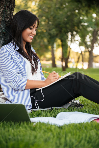 Bella cinese femminile studente ascoltare musica studiare Foto d'archivio © deandrobot