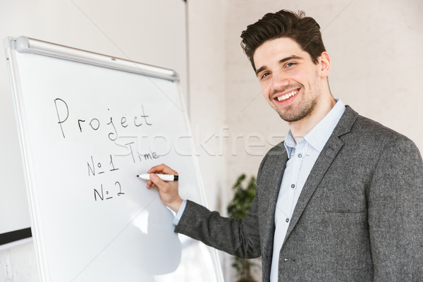 Smiling young businessman showing presentation of a project Stock photo © deandrobot