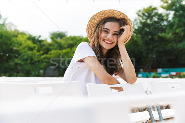 Laughing young girl sitting at the city park outdoors Stock photo © deandrobot