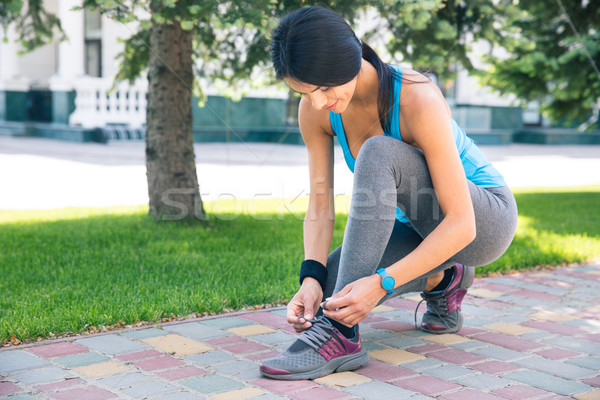 Woman tying her shoelace outdoors Stock photo © deandrobot