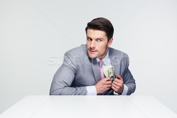 Businessman putting money in pocket Stock photo © deandrobot