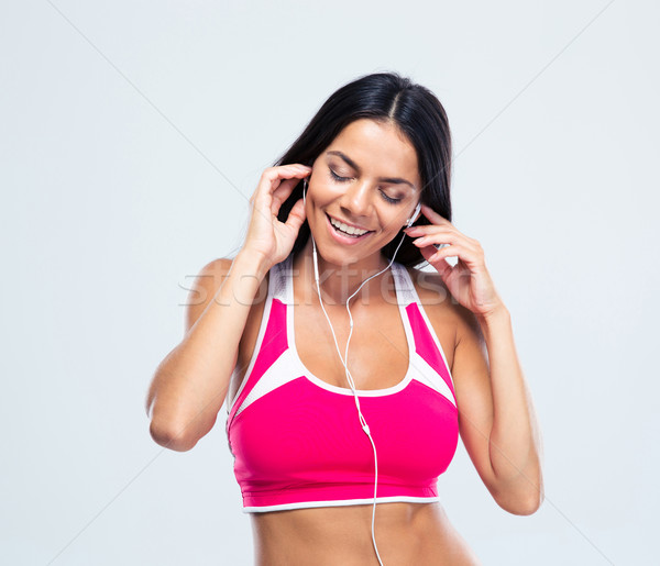 Smiling woman listening music in headphones Stock photo © deandrobot