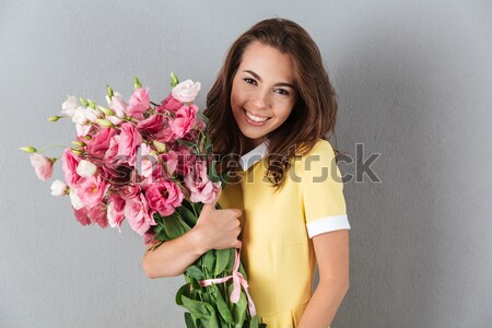 Сток-фото: улыбающаяся · женщина · цветы · улыбаясь · красивая · женщина · серый