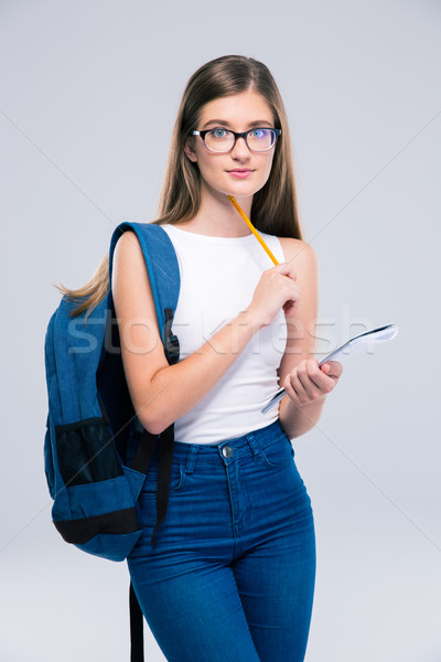 Teenager with backpack holding pencil and notebook Stock photo © deandrobot
