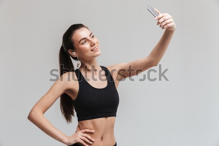 Smiling sports woman holding her ponytail Stock photo © deandrobot