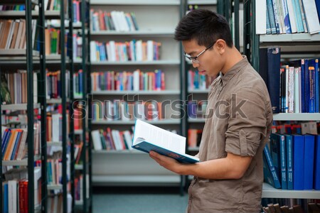 Stock photo: Man reading book in university library