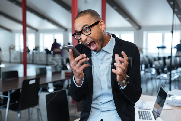 Furious bisnessman talking on the phone Stock photo © deandrobot