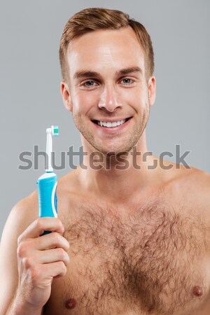 Lächelnd junger Mann Lotion rasieren Gesicht Stock foto © deandrobot