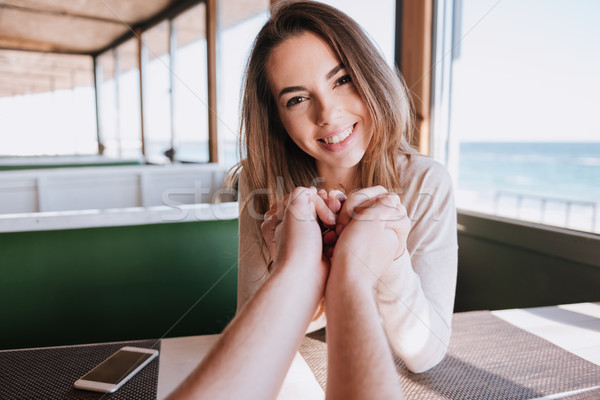 Woman on date holding hands her man in cafe Stock photo © deandrobot