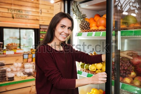 Femeie zambitoare cumpărare fructe băcănie magazin Imagine de stoc © deandrobot