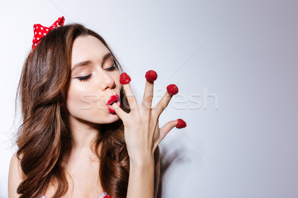 Model eating raspberries Stock photo © deandrobot