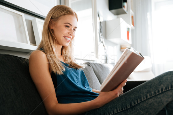 Heiter Frau Sitzung Sofa Lesung Buch Stock foto © deandrobot