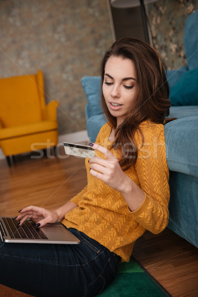 Portrait of a woman shopping on line holding credit card Stock photo © deandrobot