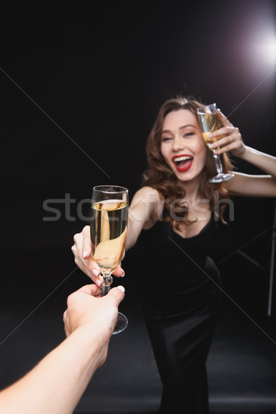 Cheerful young woman giving glass of champagne to her friend Stock photo © deandrobot