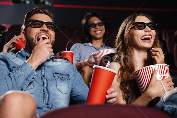 Laughing friends sitting in cinema watch film Stock photo © deandrobot