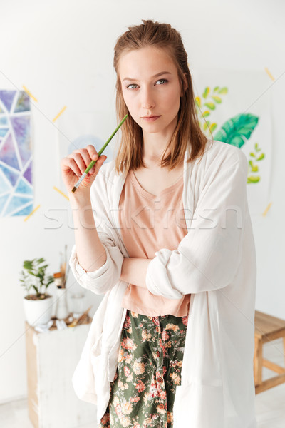 Concentrat tineri caucazian doamnă pictor spatiu de lucru Imagine de stoc © deandrobot