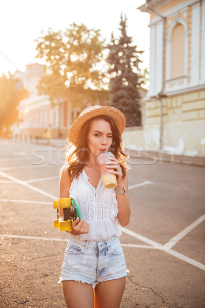 Piękna młoda kobieta deskorolka odkryty obraz pitnej Zdjęcia stock © deandrobot